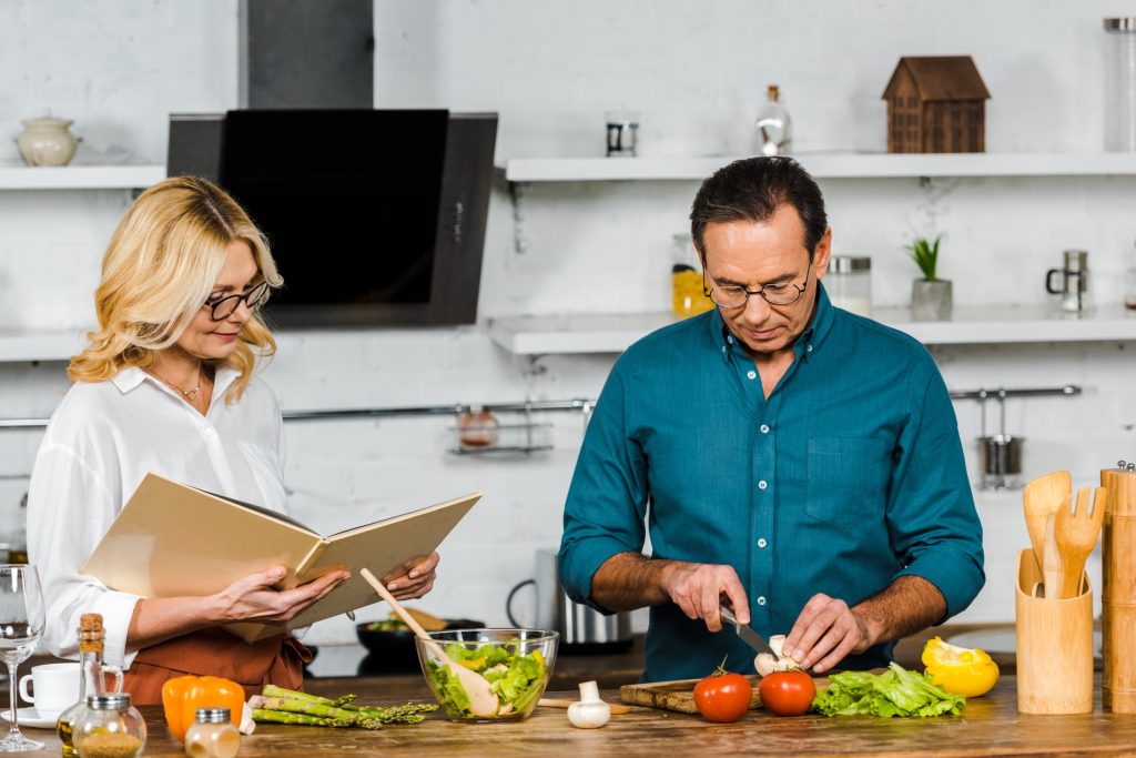 Mature man preparing a meal with his wife.