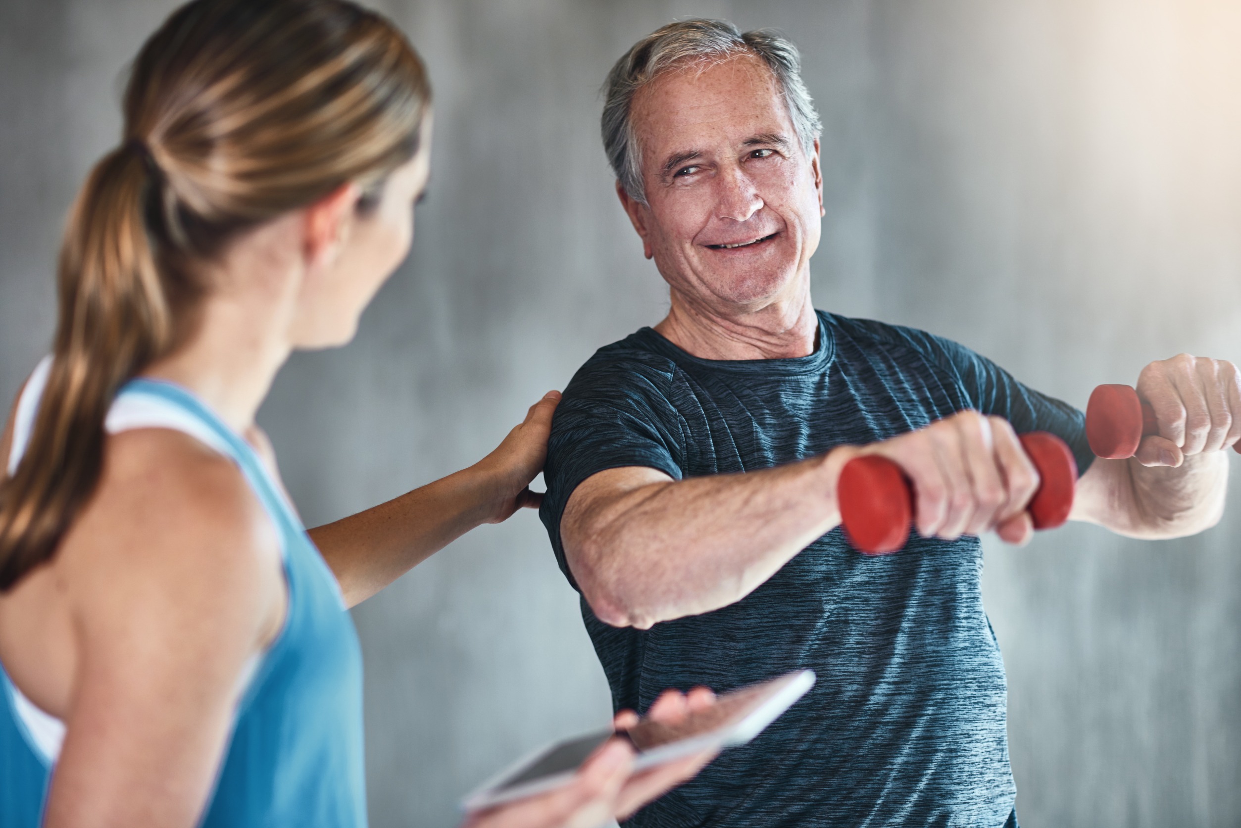 Aging man working out with a personal trainer.