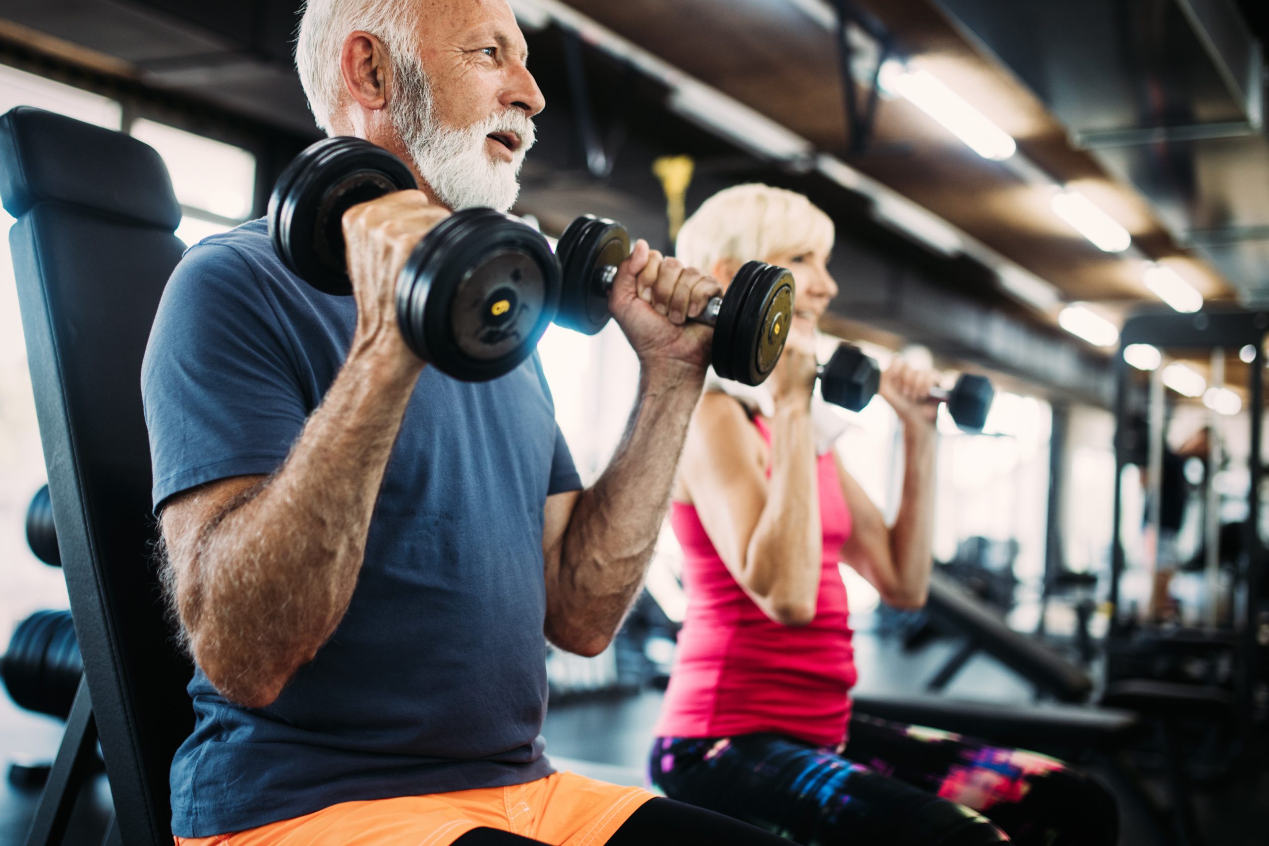 Senior lifting weights with his wife